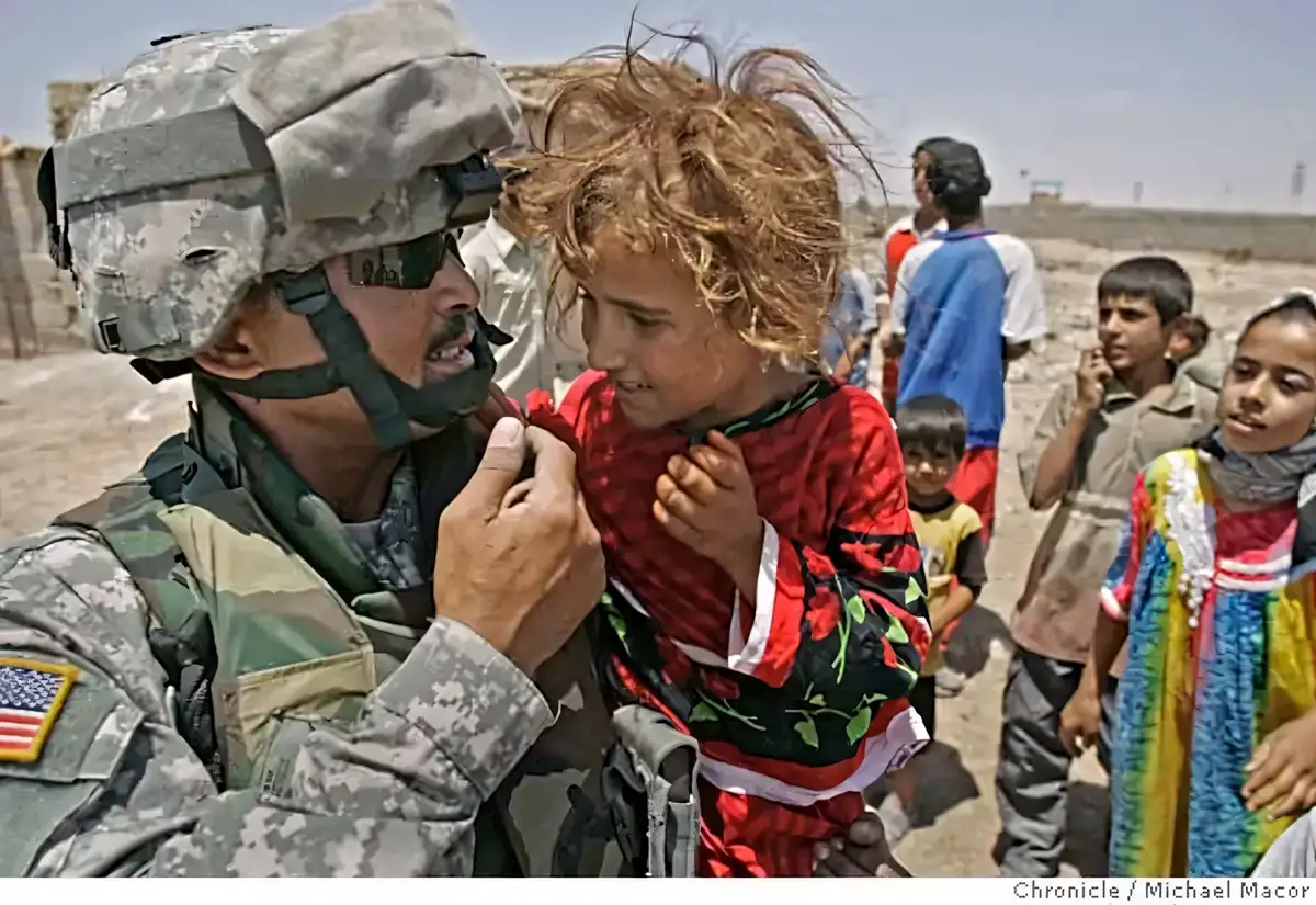 Sgt. 1st Class Susilo Suprobo visits with a young Iraqi girl in Sadr City, Baghdad